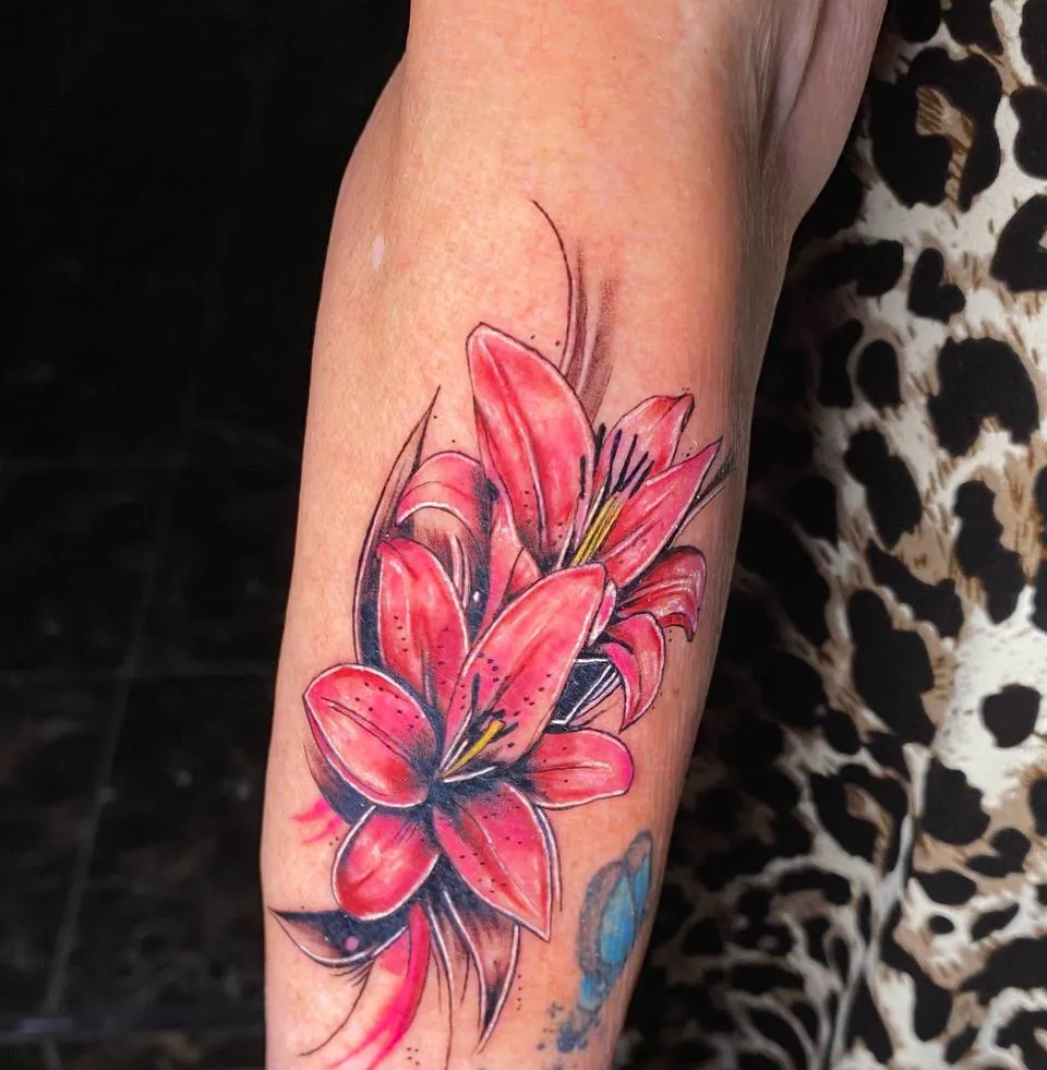 Colour tattoo of red lilies on the forearm
