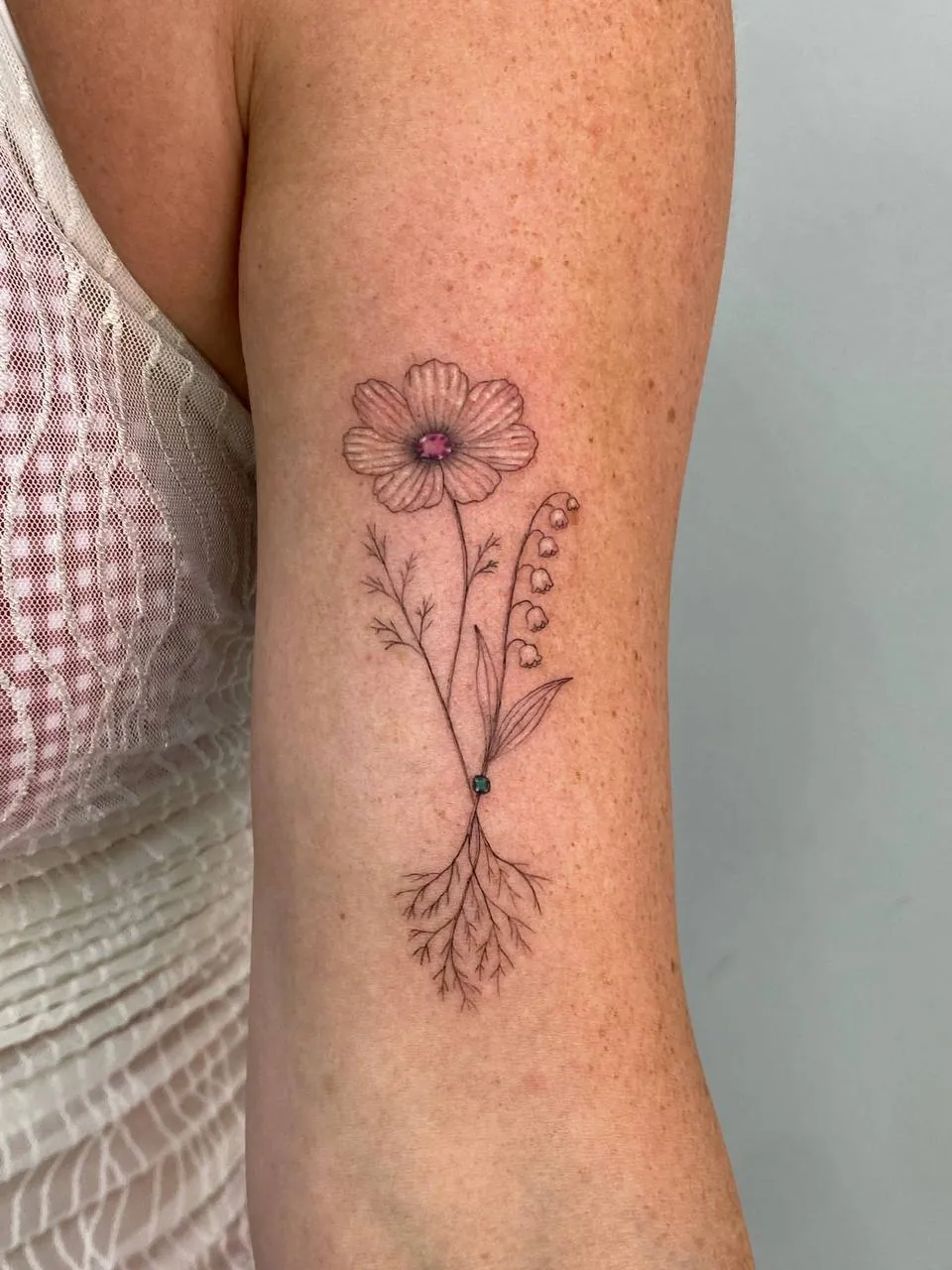 Fine-line flower with its roots and a small colour accent on the upper arm